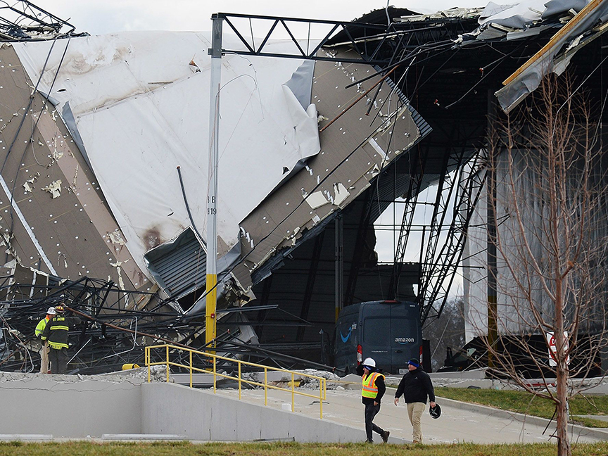 Workers walk near the area of a collapsed roof at Amazon warehouse following a tornado in Edwardsville, Illinois. Photo: Bloomberg.