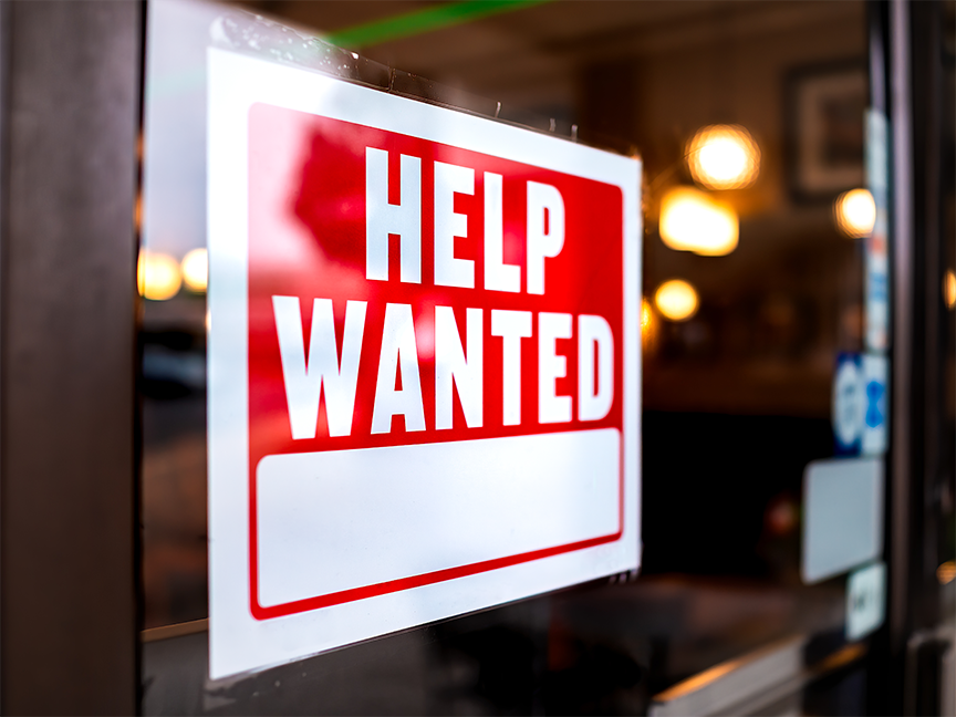 A sign reading 'Help Wanted' hangs in the window of a business. Photo: Getty Images.