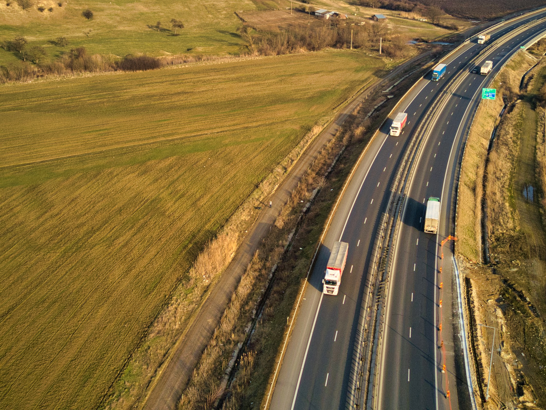 Freight trucks drive on a highway. Photo: Stefan Doncean/ Pexels.