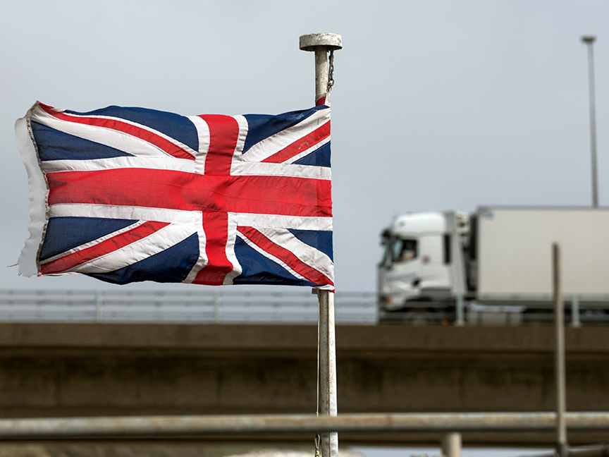 A truck passes a British Union flag at the Port of Dover Ltd. in Dover, U.K. Photo: Bloomberg.