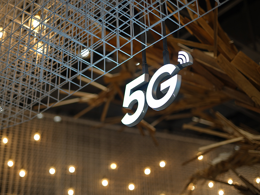 A sign reading '5G' hangs from metal beams. Photo: Pexels.