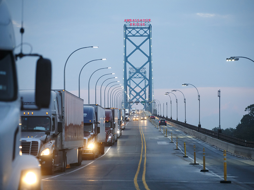 Commercial trucks and passenger vehicles drive across Ambassador Bridge on the Canada-U.S. border in Windsor, Ontario. The bridge connects Windsor to Detroit and facilitates over 30% of all Canada-U.S. road trade. Photo: Bloomberg.