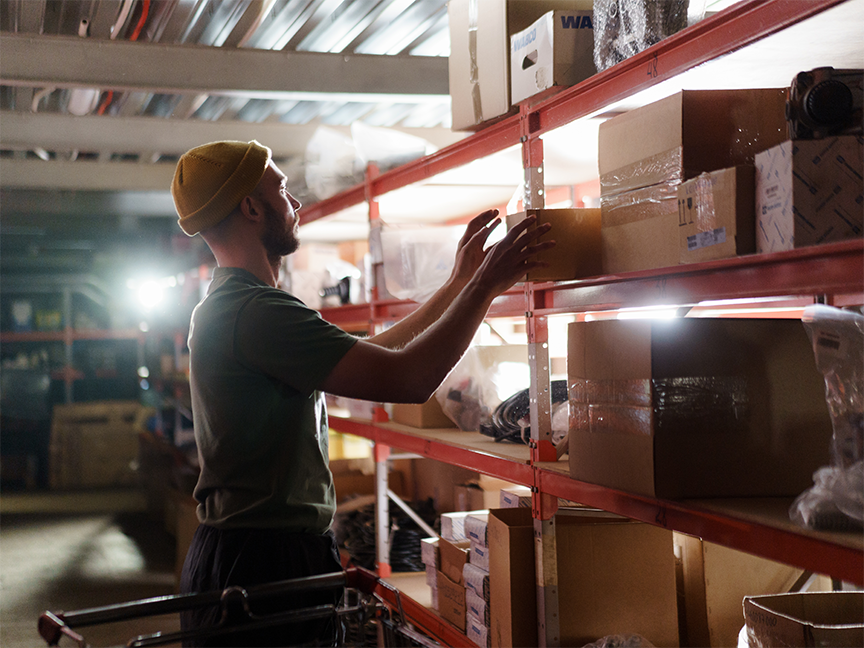 A worker surveys inventory on a warehouse shelf. Photo: C Technical/ Pexels.