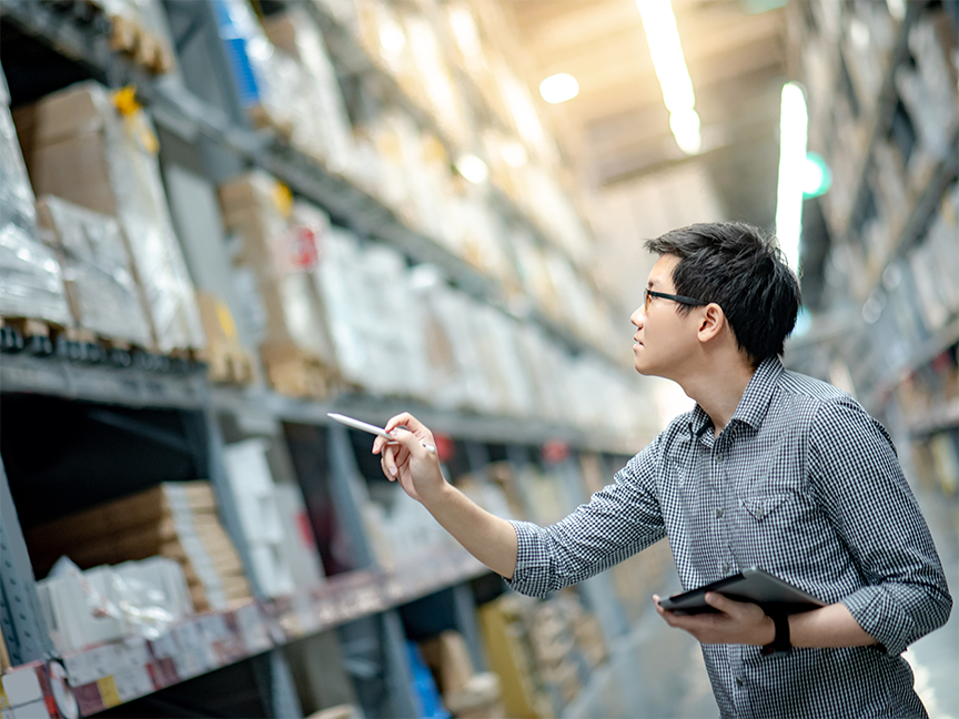 A warehouse worker takes stock of inventory. Photo: Getty.