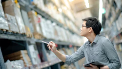 A warehouse worker takes stock of inventory. Photo: Getty.