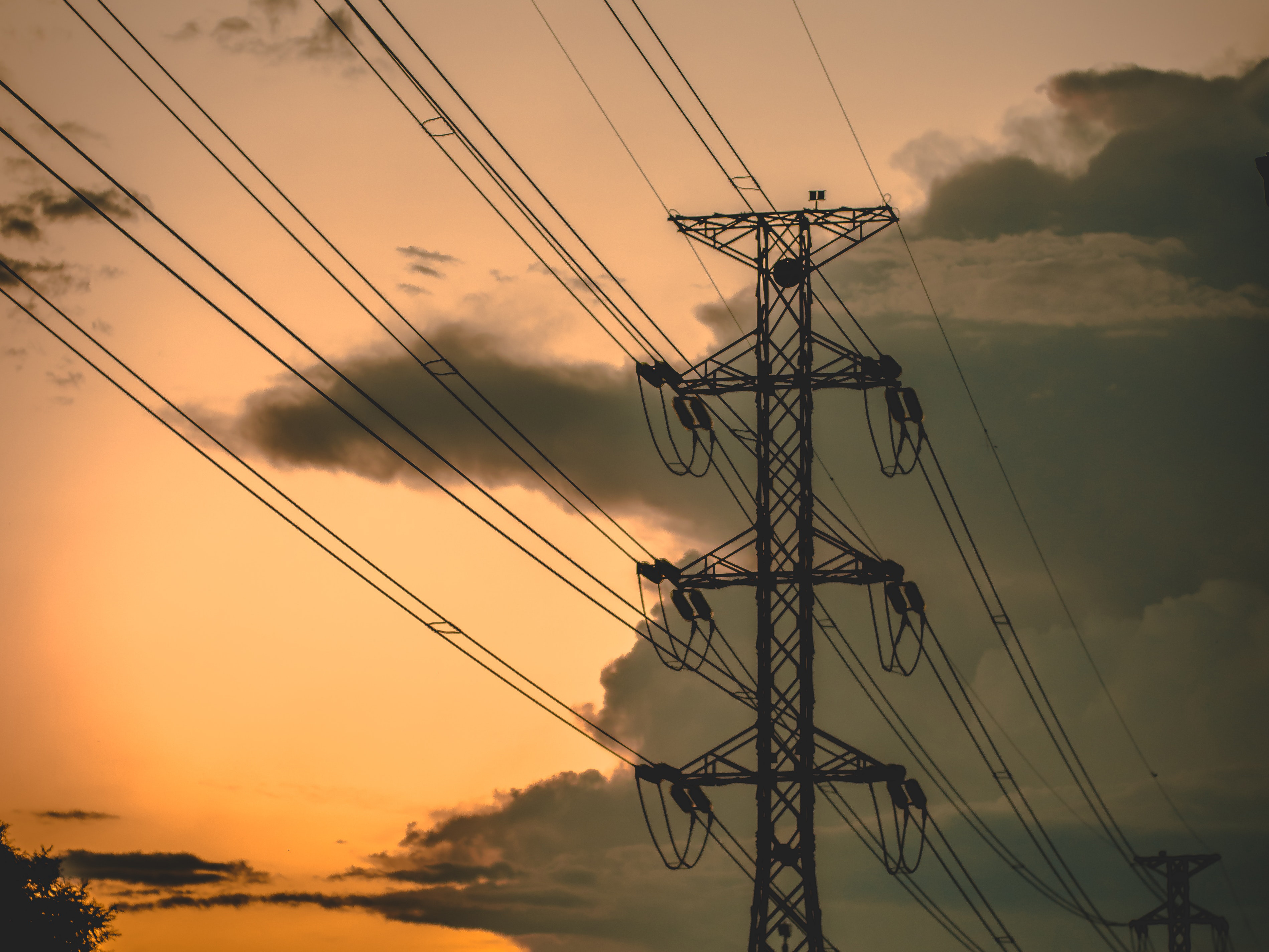 A silhouette of transmission towers and power lines at dusk. Photo: Pok Rie/ Pexels.