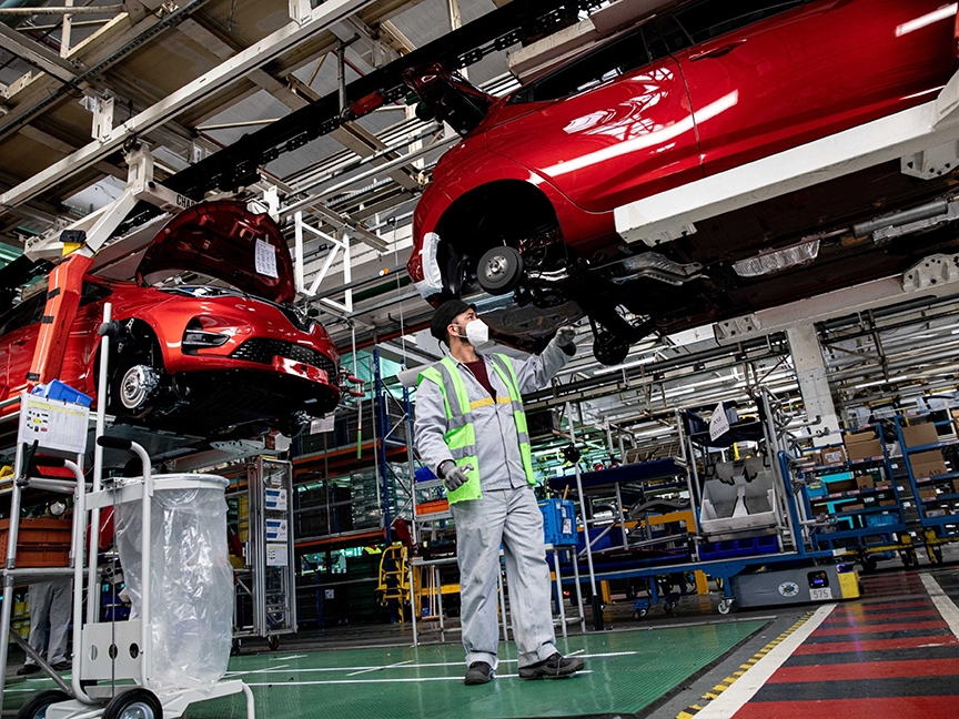 An employee inspects a rear axle fitting on a Renault electric automobile at the Renault SA factory in Flins, France. Photo: Bloomberg.