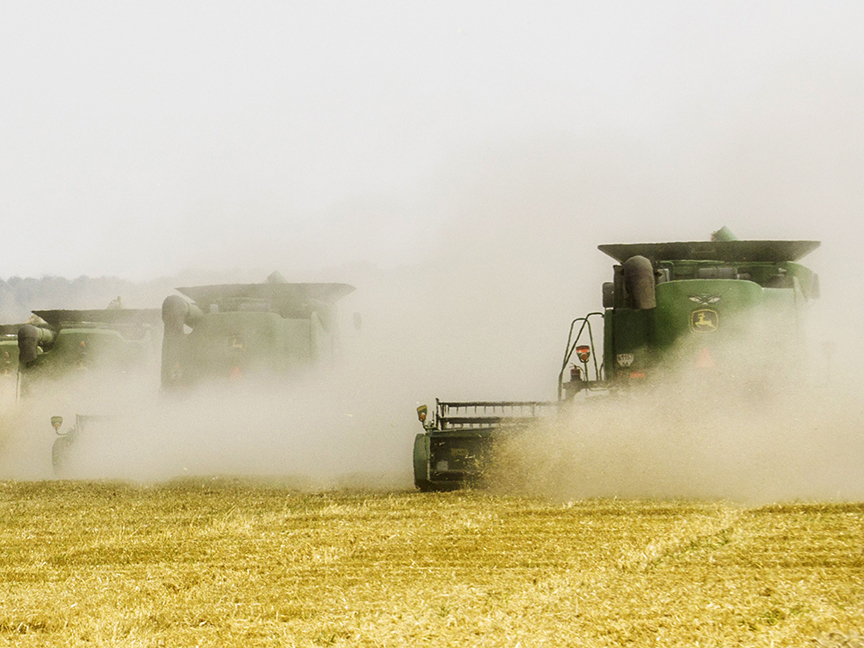 Deere & Co. combine harvesters create clouds of dust as they harvest a field of wheat in Varva, Ukraine. Photo: Bloomberg.