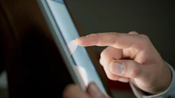 Close up of a finger touching a tablet device. Photo: Shutterstock.