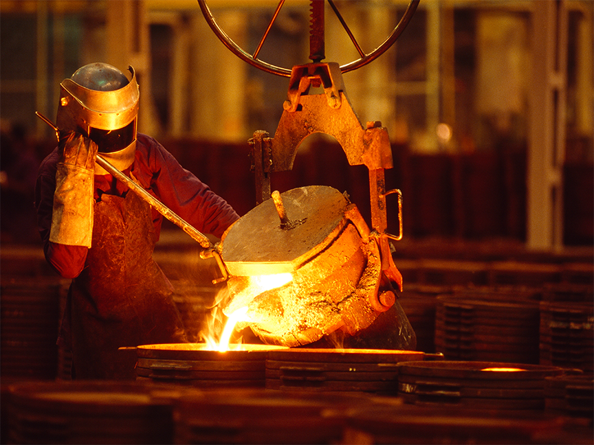 A foundry worker pours molten steel into a casting. Photo: Getty.