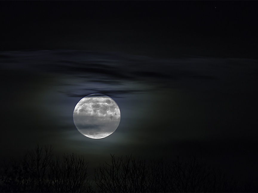 A full moon obscured by clouds at night. Photo: Michael Treu/ Pixabay.