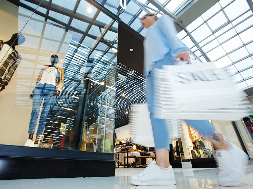A woman walks with shopping bags in a mall. Photo: Shutterstock.