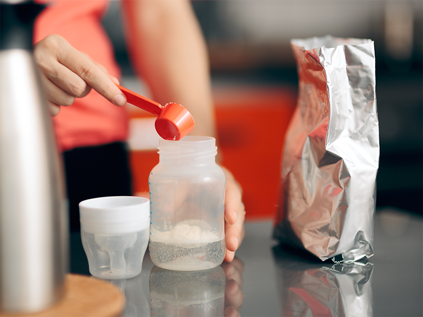 A parent prepares baby formula in a bottle. Photo: Getty.