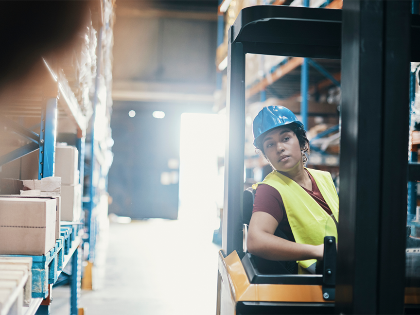 A warehouse worker drives a forklift. Photo: Getty.