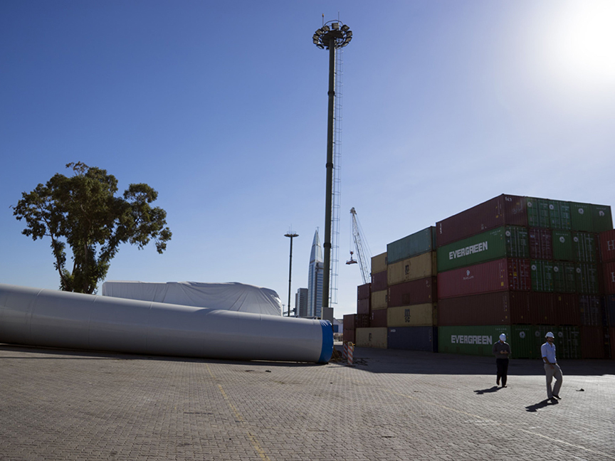 Workers walk next to wind turbine equipment and shipping containers at the Port of Montevideo in Montevideo, Uruguay. Photo: Bloomberg.