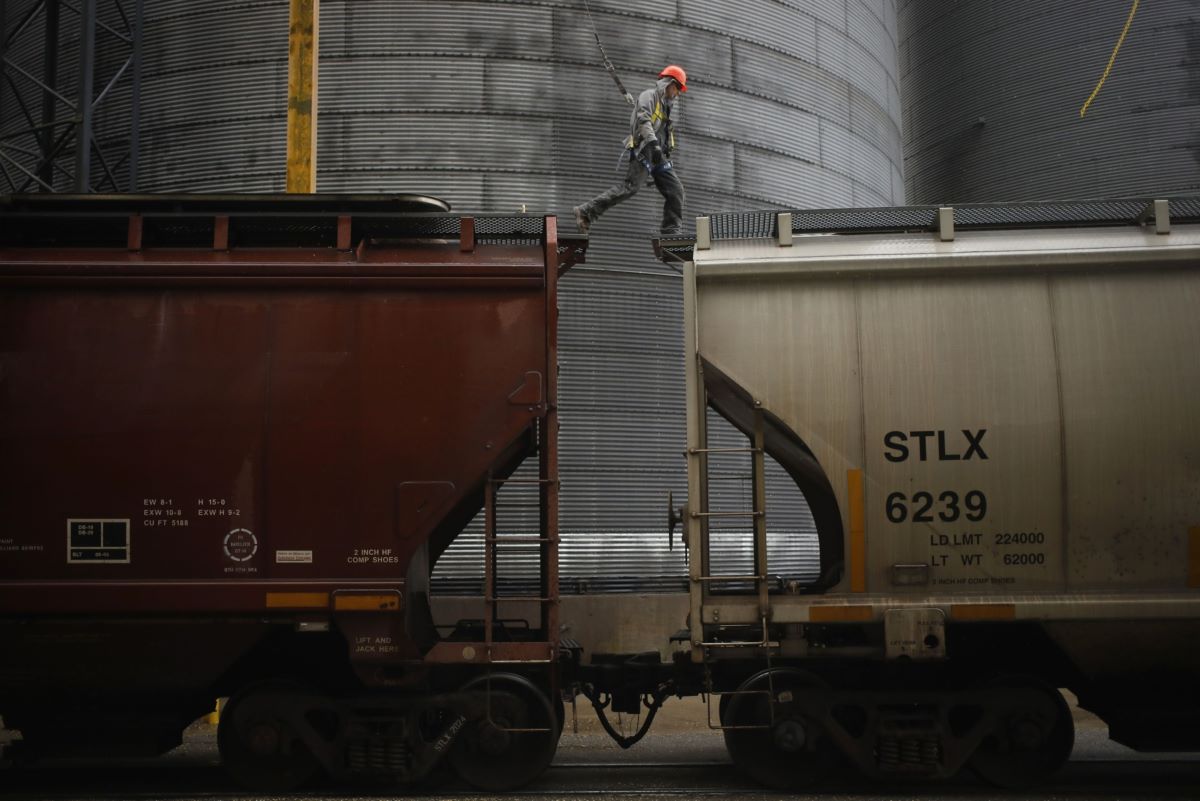 A worker walks across the top of a railroad grain hopper car at the Kokomo Grain Co. Inc. transloading facility in Edinburgh, Indiana. Photo: Bloomberg