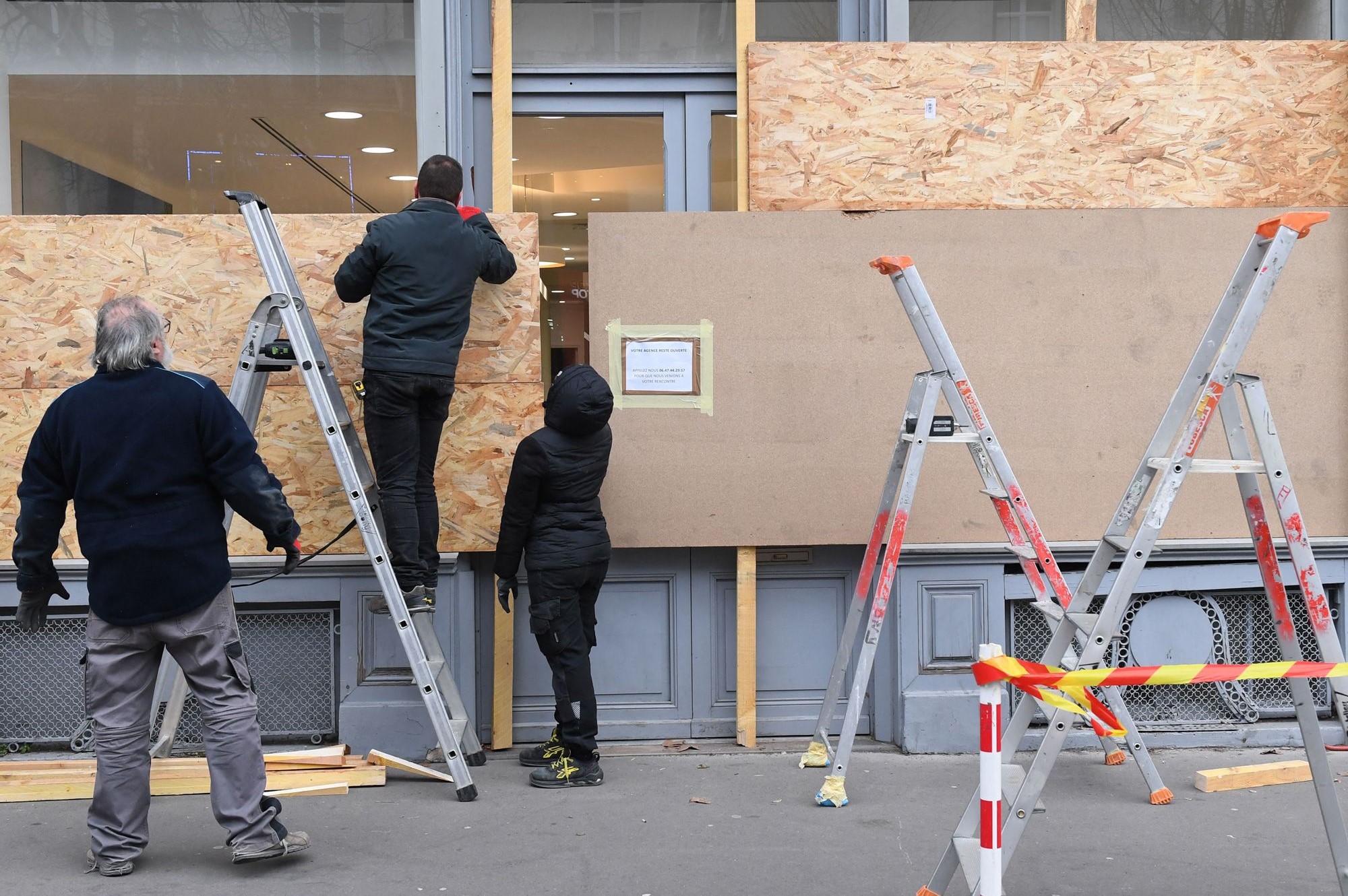 Workers board up a store ahead of a demonstration, in Paris on Jan. 19. Photo: Bloomberg