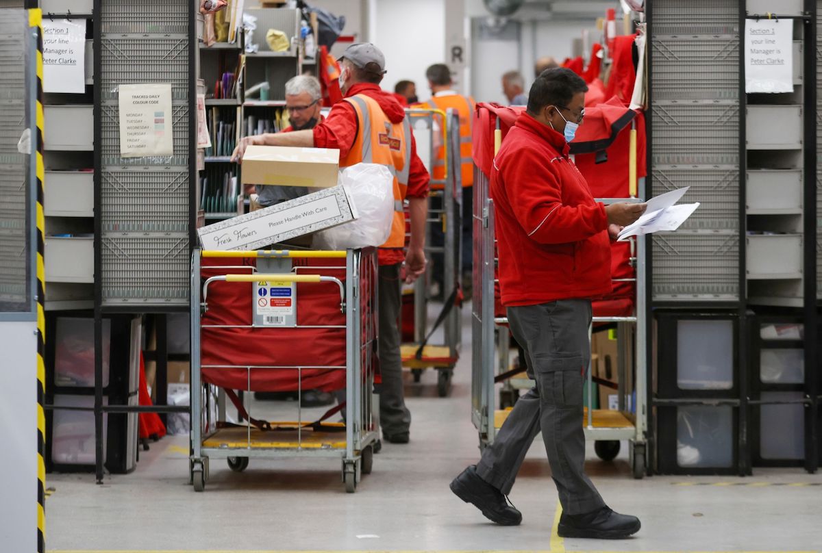An employee sorts through letters at the Royal Mail Plc sorting office in Chelmsford, U.K.