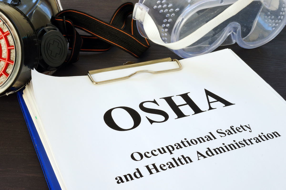 A pile of documents sits on top of a clipboard with the top piece of paper reading 'OSHA Occupational Safety and Health Administration.' Photo: iStock.com/designer491