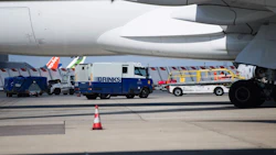 A Brinks security van beside a Boeing Co 777 passenger plane. Photographer: Nathan Laine/Bloomberg