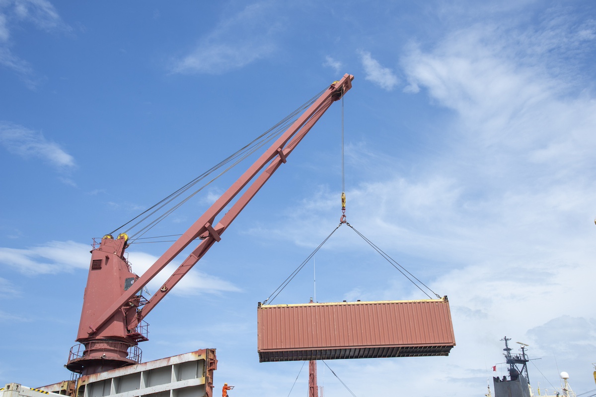 container ship commercial vessel alongside in port for loading and discharging containers services in maritime transports in World wide logistics