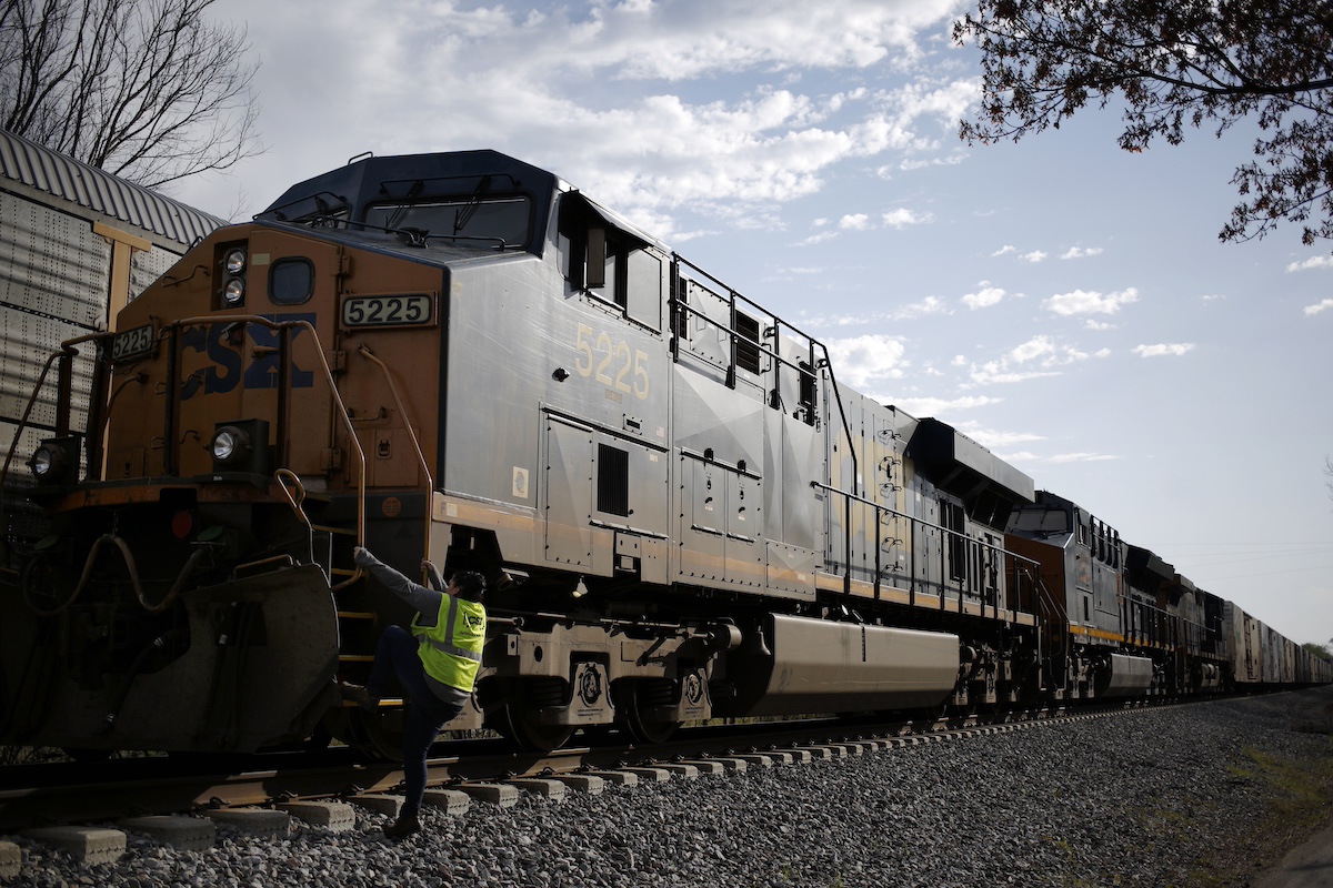 A CSX conductor climbs aboard a freight train. Photo: Luke Sharrett/Bloomberg