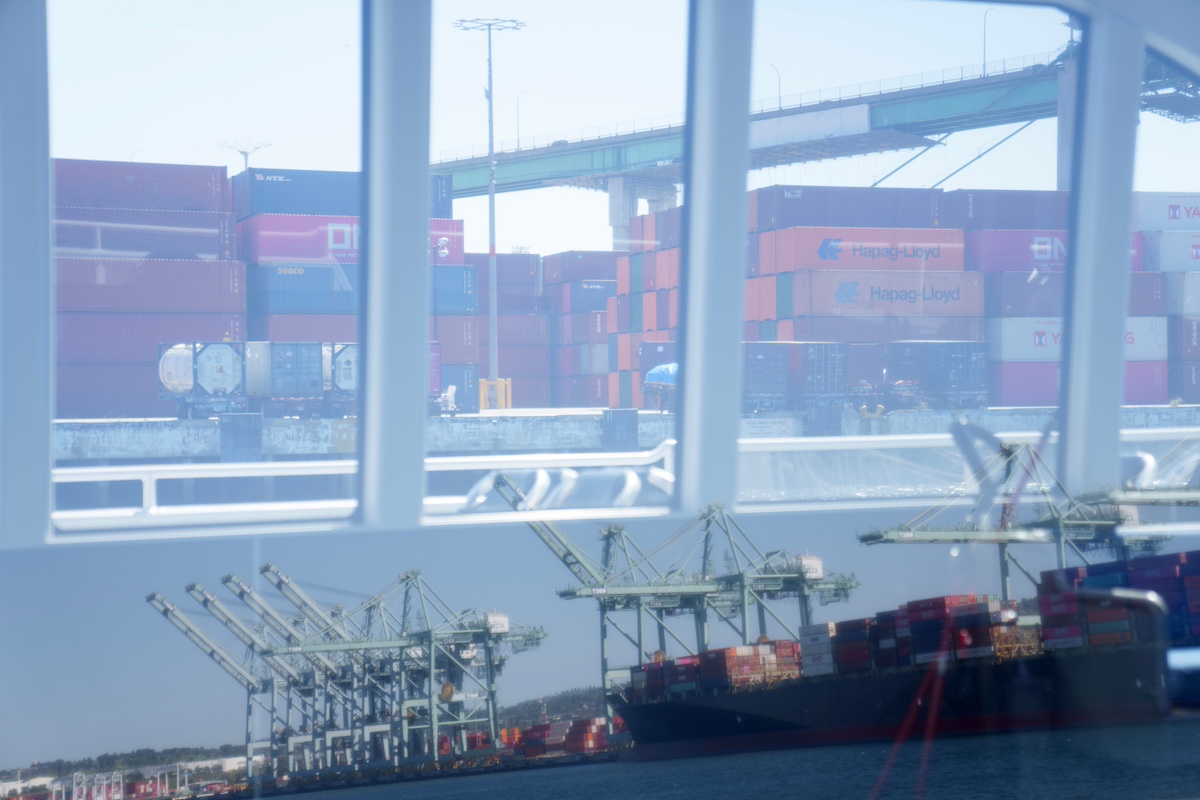 Cranes reflected in a boat window at the Port of Los Angeles in Wilmington, California. Photographer: Eric Thayer/Bloomberg