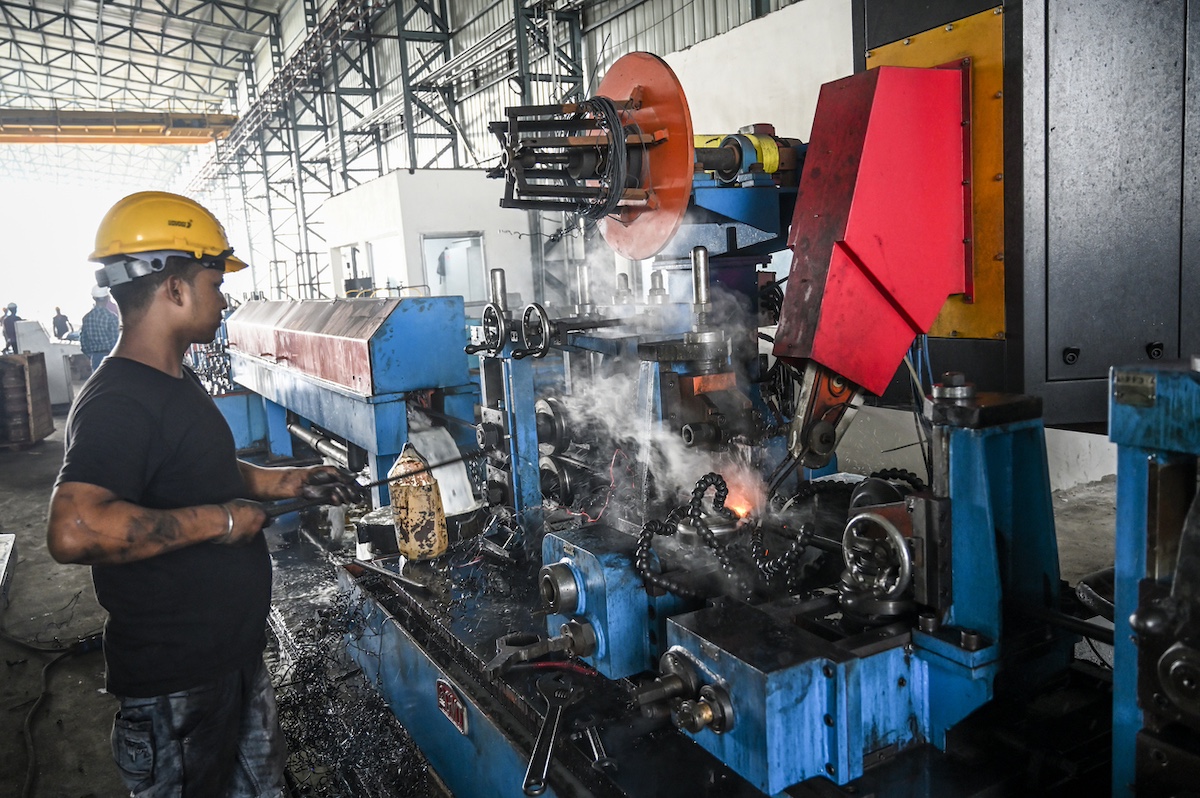 Iron tube welding in a factory in India. High efficiency switch welder operating in Raipur, India.