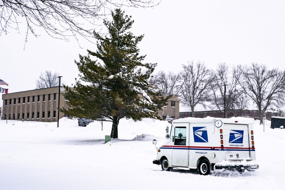 A United States Postal Service truck drives through snow in West Des Moines, Iowa. Photographer: Al Drago/Bloomberg