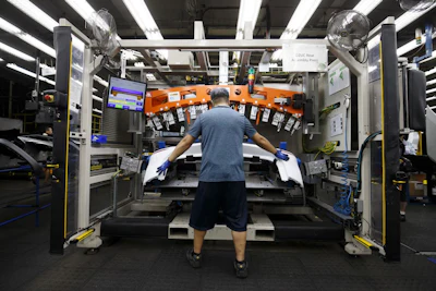 An employee assembles a rear bumper at an auto parts manufacturing facility in Guelph, Ontario. Photographer: Cole Burston/Bloomberg