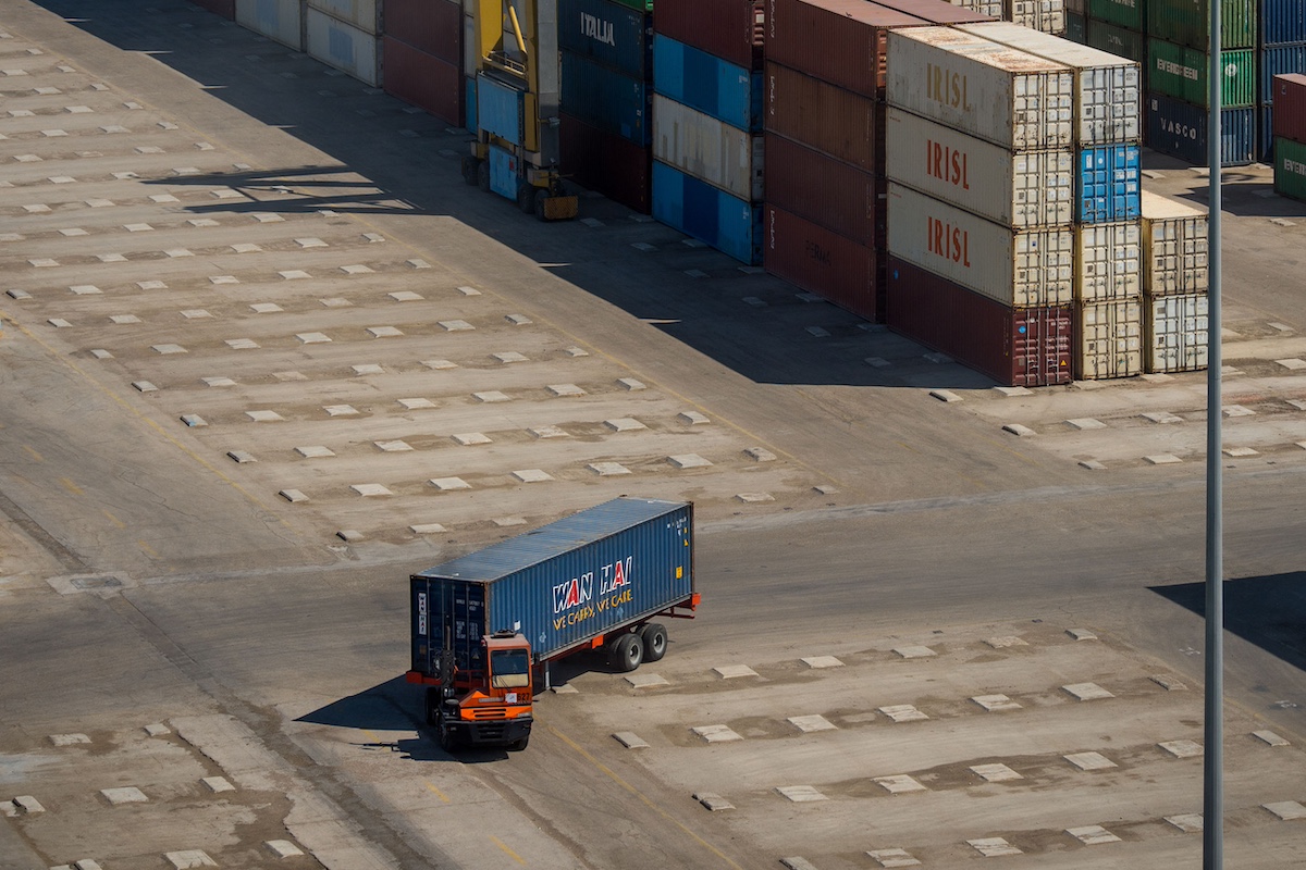 A truck carries a shipping container through a storage area at Bandar Imam Khomeini (BIK) port in Bandar Imam Khomeini, Iran. Photographer: Ali Mohammadi/Bloomberg