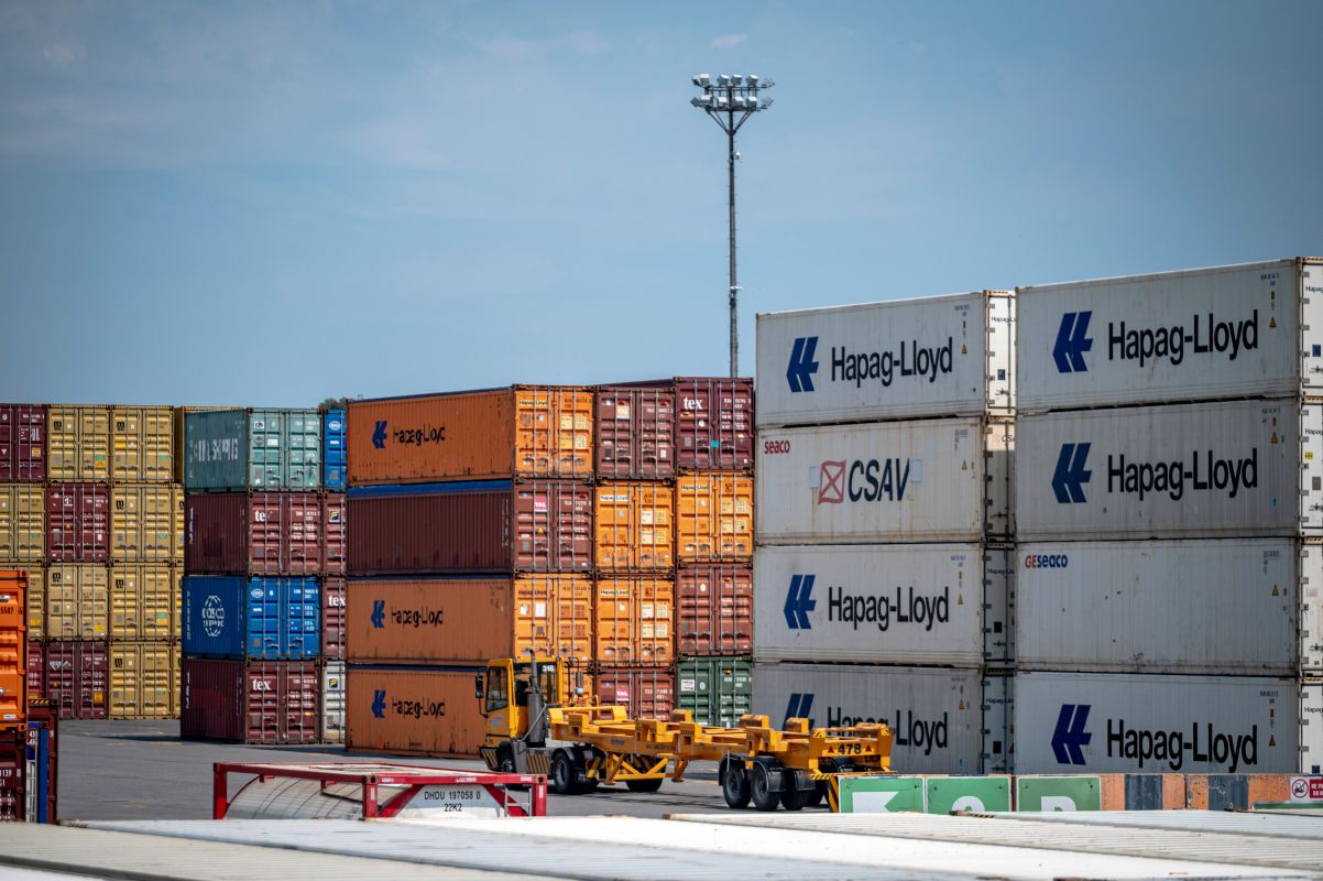 A truck drives past shipping containers at the Port of Montreal. Photographer: Andrej Ivanov/Bloomberg