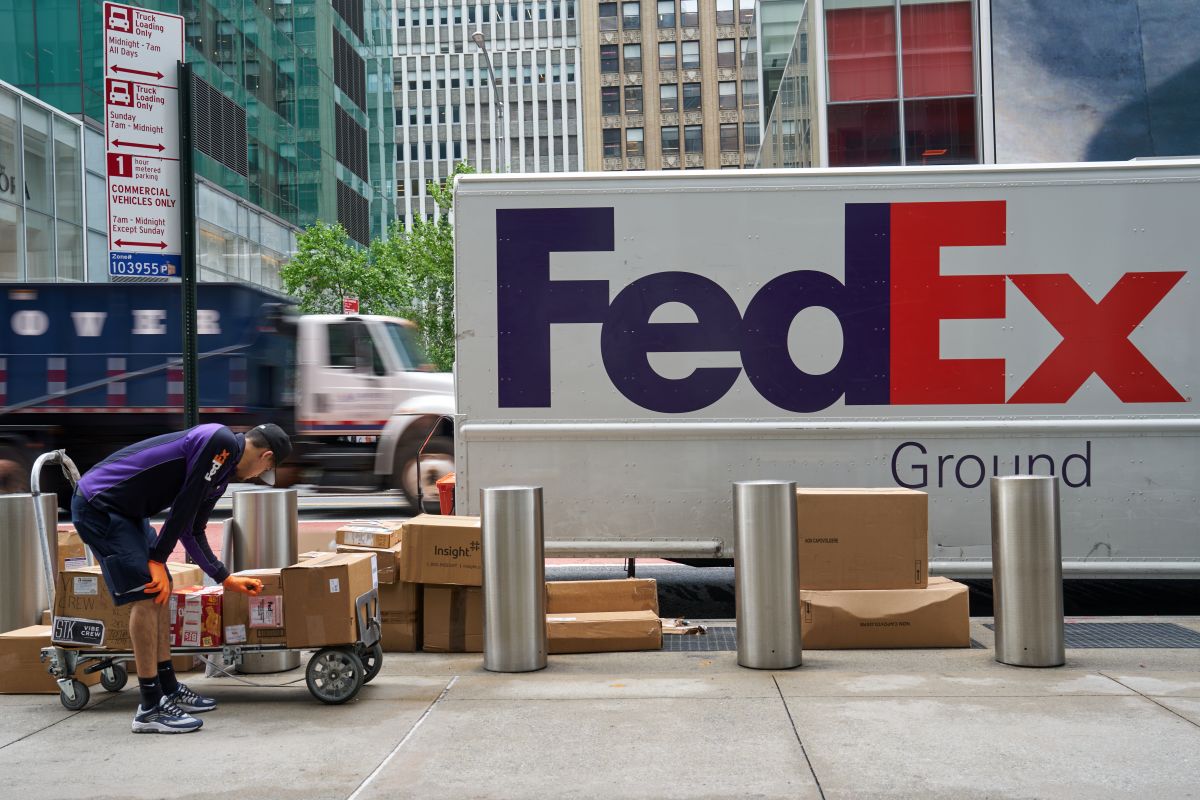 A FedEx worker unloads packages from a delivery truck in New York. Photographer: Bing Guan/Bloomberg