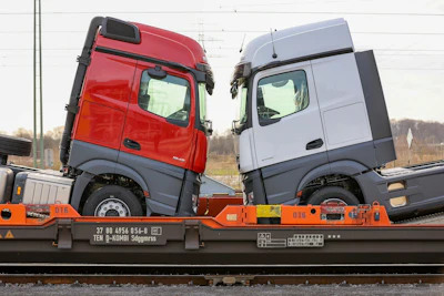 New haulage trucks loaded onto a train outside the Daimler AG truck factory in Woerth, Germany. Photo: Alex Kraus / Bloomberg