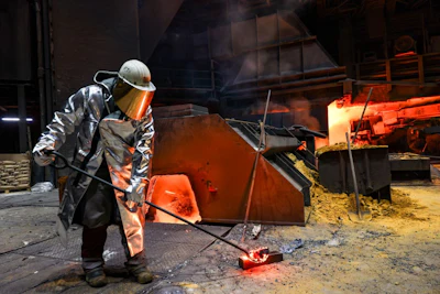 A worker collects a sample of molten steel from a blast furnace at a steel plant in Duisburg, Germany. Photographer: Alex Kraus/Bloomberg