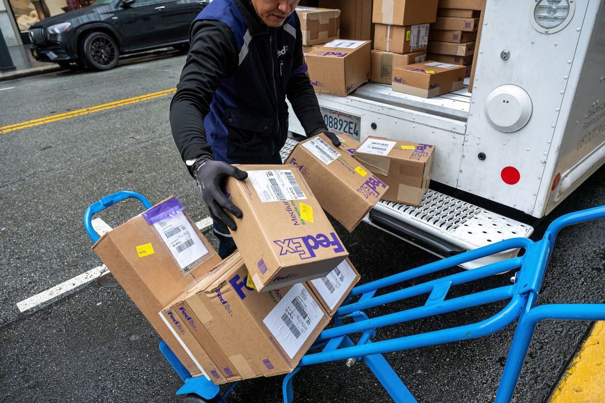 A worker unloads packages from a FedEx truck in San Francisco. Photographer: David Paul Morris/Bloomberg