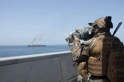 A U.S. service member watches a ship transit the Arabian Sea. Source: U.S. Navy