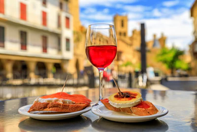 Tostadas with salmon and crab and baked cheese pintxos or tapas with a glass of Spanish rose wine outside a cafe in the medieval town of Olite, Spain. Photo: iStock/SvetlanaSF