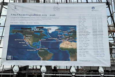 A poster depicting a world map with red lines drawn between cities, which are all listed on the right