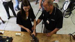 Richard Perry of Chief Automotive (right) helps a journalist set up equipment at a recent media event. Collision Repair magazine was the only Canadian publication present.
