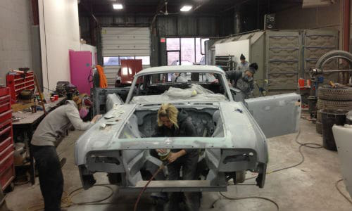 The staff of Ink & Iron, hard at work on the custom '63 Lincoln that will be on display at the Kreator Custom Motorcycles booth.