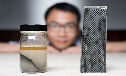 A research team at Georgia Tech has developed a new way of recycling carbon. Pictured above, one of the men involved in the project Kai Yu shows off the team's method &ndash; immersing carbon fibre composites in alcohol.
