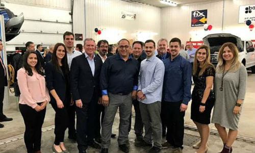 St&eacute;phane Plante and his two sons at the Grand Opening event, accompanied by Fix Auto headquarters employees.