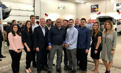 St&eacute;phane Plante and his two sons at the Grand Opening event, accompanied by Fix Auto headquarters employees.