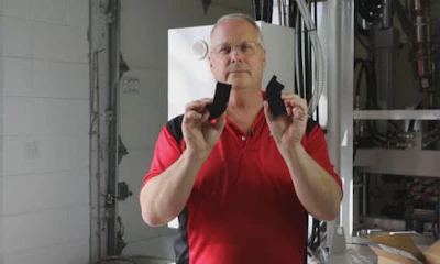 Carl Dumele, CEO of Aeromotive holds up two parts for a visual inspection. The part on the left is the original, damaged bracket. The one on your right is a new part Aeromotive turned out with its 3D printer.