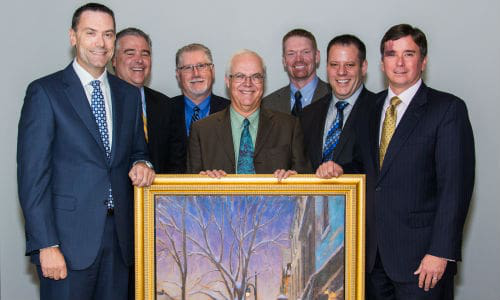 Axalta Coating Systems recently honoured its 60-year partnership with NAPA Canada at its Canadian headquarters in Montreal, Quebec. From left: Representing NAPA Canada, Alain Masse, President of UAP; Eric L&eacute;veill&eacute;, Vice President, CMAX and Paint & Body Supplies; Tom Hunt, Vice President, Product Development; Representing Axalta, Robert Searle, Refinish Product & Marketing Manager-Axalta Canada; Benoit Goulet, Regional Sales Manager, Quebec/Atlantic-Axalta Canada; Brent Jamieson, Axalta North America Sales Director; and Troy Weaver, Axalta Business Director pose with Axalta's gift to NAPA titled 'Winter Evening, St-Lawrence Boulevard' by Montreal artist Richard Montpetit. Photo by Eve Richard.