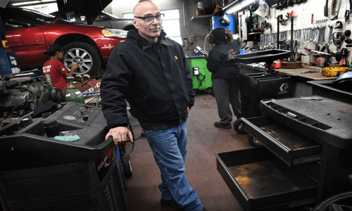 Teacher Matt Lijewski stands by the emptied out toolboxes in his classroom.