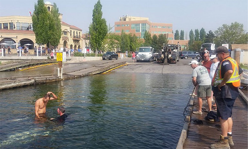 A member of Mario Towing's team gets into Okanagan Lake to hook the winch up.