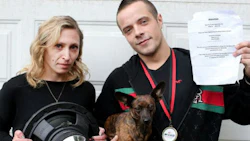Dustin Hamilton with his girlfriend, Katrina Jourdenais, and their dog, Luna. Hamilton is a professional car audio installer, but it turns out his neighbours think he's too good at his job. The sheet of paper he's holding was put up in his neighbourhood, asking residents to complain to police about his car stereo.
