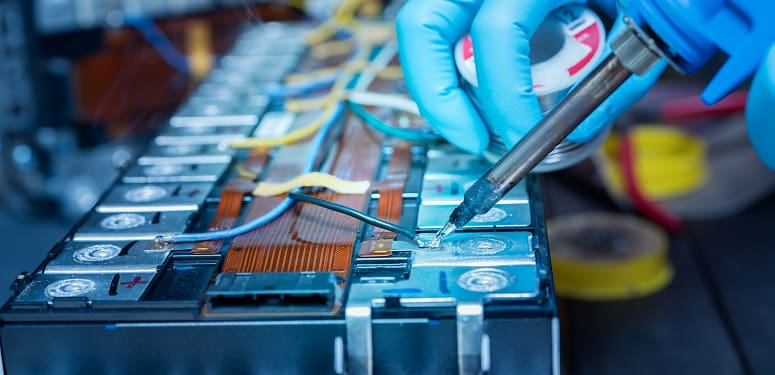 Technician use soldering iron to solder metal and wire of lithiu